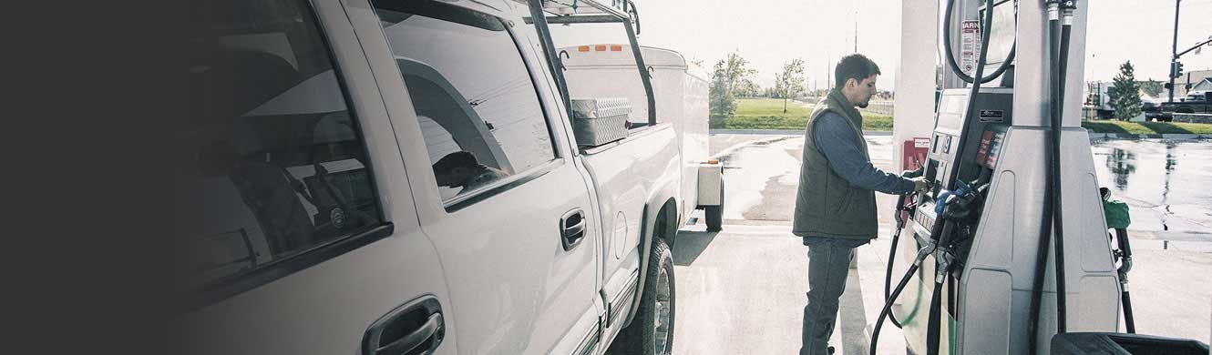 Man fueling truck at pump.