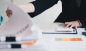 Woman reviewing documents at a desk.