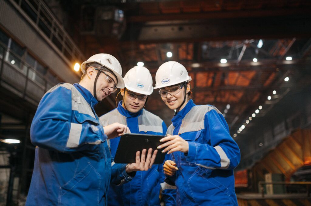 A team of employees in a warehouse review the power of fleet cards on a shared tablet.