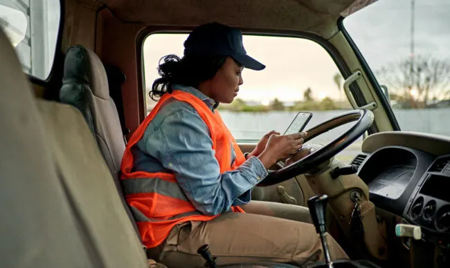 Operator reviewing fleet card security information during a fuel stop.