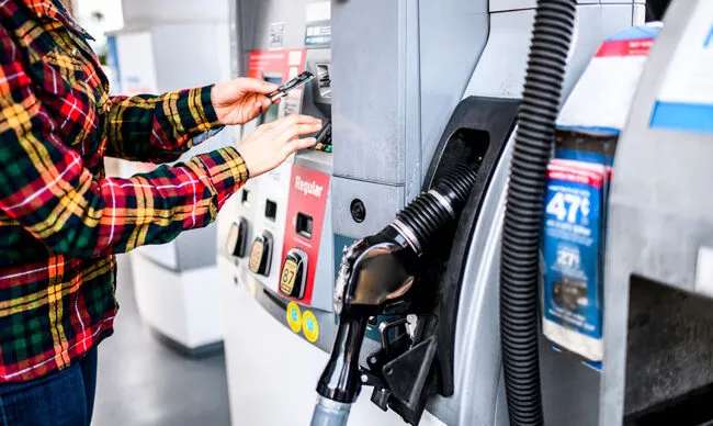 Driver paying with a fuel card to streamline fleet maintenance.