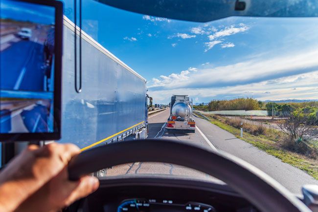 View from a commercial fleet truck on a highway following tanker and freight vehicles, representing route optimization, telematics, fuel management, and fleet efficiency.