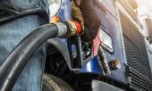 A truck driver prepares to fuel his rig after using a fleet card.