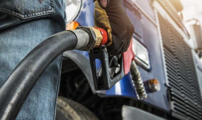 A truck driver prepares to fuel his rig after using a fleet card.