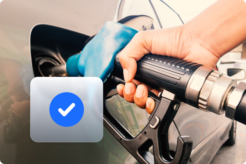 A closeup of a person at a gas station filling their vehicle with gas.